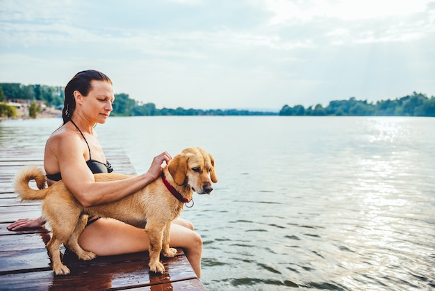 Vrouwenzitting met hond op dok