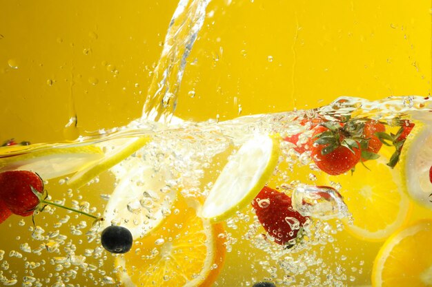 Vruchten in water tegen geel concept als achtergrond versheid