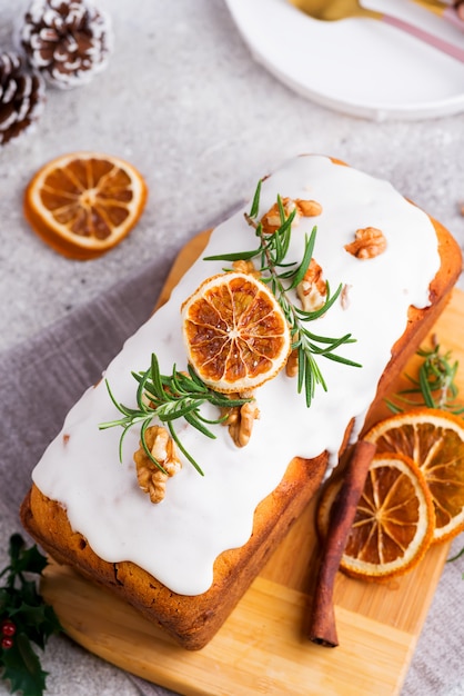 Vruchtencake bestrooid met ijsvorming, noten en droge oranje steen, plat liggend. Kerst- en wintervakantie zelfgemaakte cake