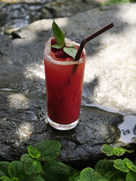 Vruchtensap fruit smoothie vruchtensap vruchtensap in glas Geplaatst op een rots bij de waterval