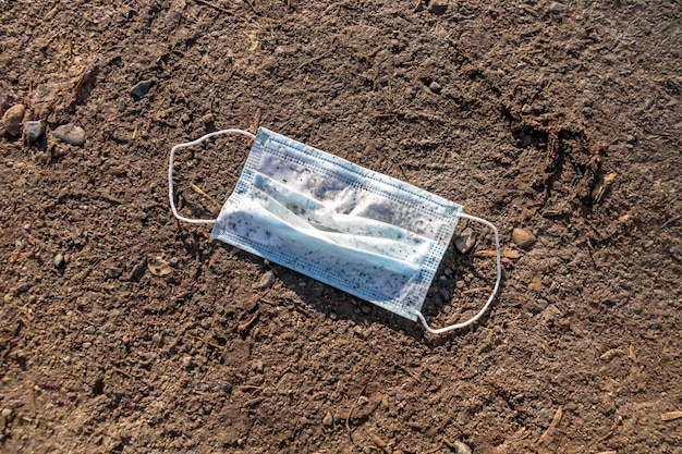 Vuil medisch masker op de grond.