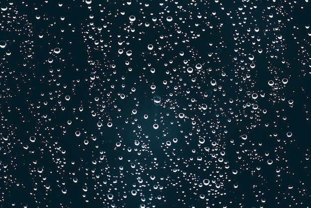 Vuil vensterglas met druppels regen.