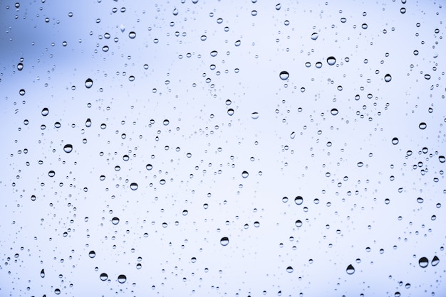 Vuil vensterglas met druppels regen.