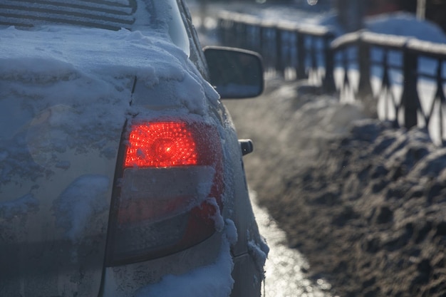 Vuile auto achterlicht met sneeuw op winteravond close-up met selectieve focus