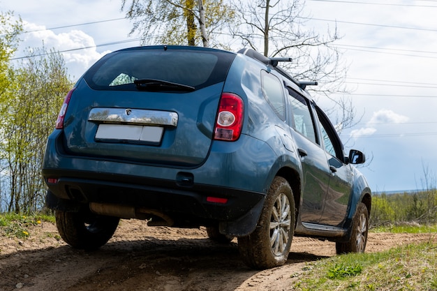 Vuile auto op modderige weg uitzicht vanaf achterkant.