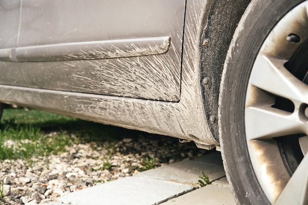 Vuile auto zonder spatlappen achter de autoband Modderspatten op het autooppervlak