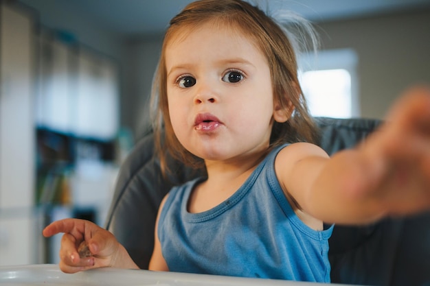 Vuile kleine baby jongen meisje in de keuken eten ochtendmaaltijd Gelukkige familie levensstijl eten concept Kid zelfvoeding vast voedsel