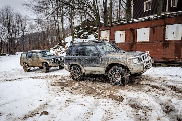 Vuile off-road auto met ketting op band in de winter