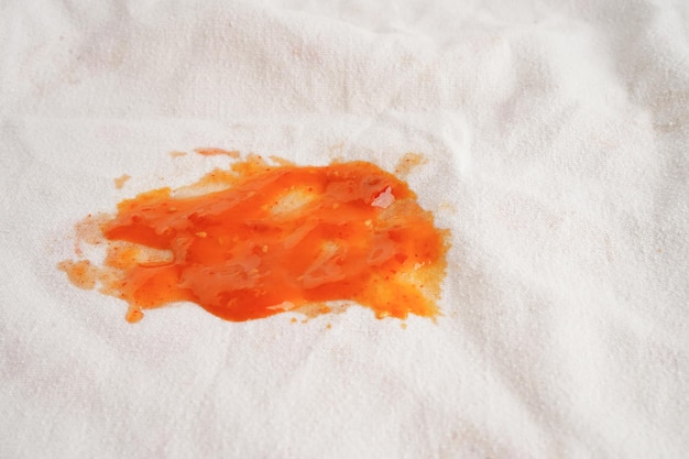 Vuile tomatensousvlek of ketchup op doek om te wassen met waspoeder schoonmaak huishoudelijk concept