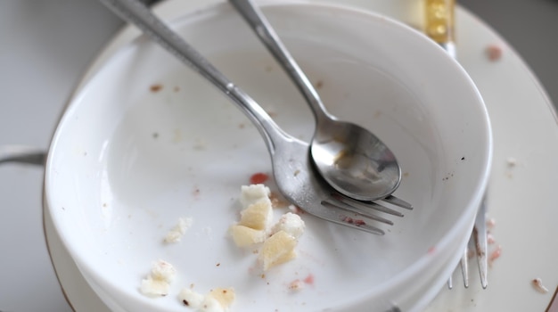 Vuile vaat close-up lepel vork platen met etensresten gestapeld in de gootsteen