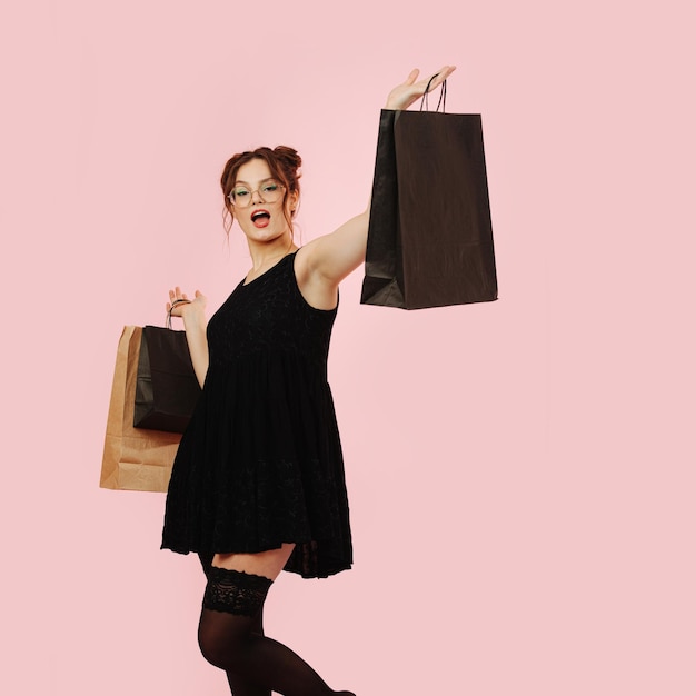 Vulgar eccentric lady wearing black mini dress and stockings with shopping bags