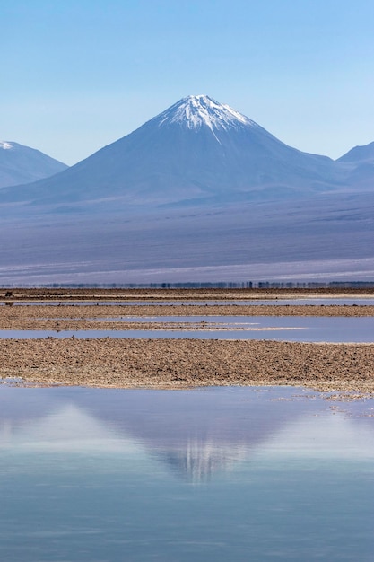 Foto vulkaan weerspiegeld in zoutvlaktes meer in de atacama woestijn