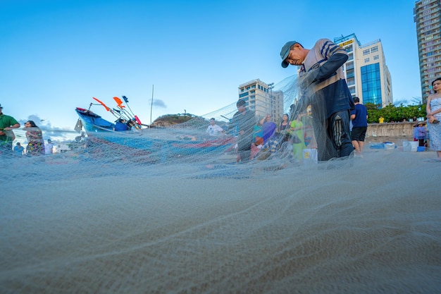 Vung Tau VIETNAM 14 MEI 2023 Visser die zijn net uitwerpt bij zonsopgang of zonsondergang Traditionele vissers bereiden het visnet voor