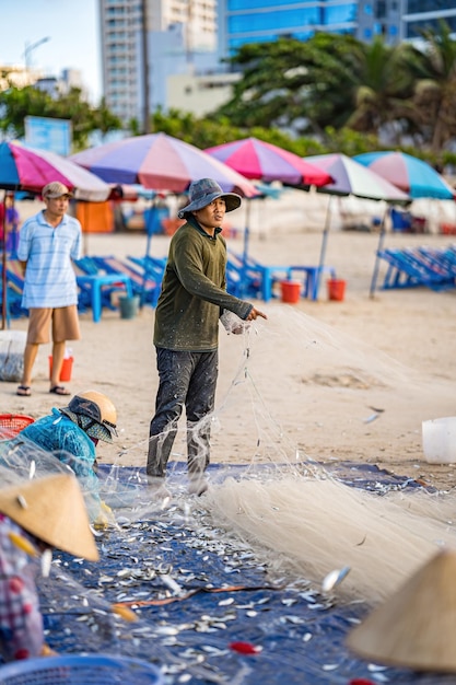 Vung Tau VIETNAM 14 MEI 2023 Visser die zijn net uitwerpt bij zonsopgang of zonsondergang Traditionele vissers bereiden het visnet voor