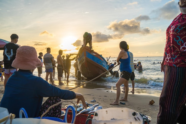Foto vung tau vietnam 20 augustus 2022 visser werpt zijn net uit bij zonsopgang of zonsondergang traditionele vissers bereiden het visnet voor vissers op het strand bij de visserij