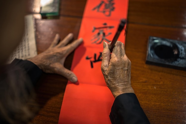 Vung Tau Vietnam JAN 12 2023 Vietnamese scholar writes calligraphy at Long Son Calligraphy festival is a popular tradition during Tet holiday Writing couplets for Spring Festival new year