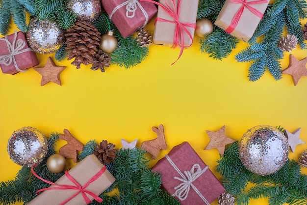 Vuren tak, kegels en vintage speelgoed decoratie op Kerstmis of Nieuwjaar op gele achtergrond.