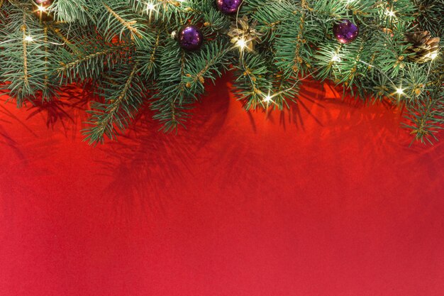 Vuren takken met kerstballen en slinger op rood frame bovenaanzicht