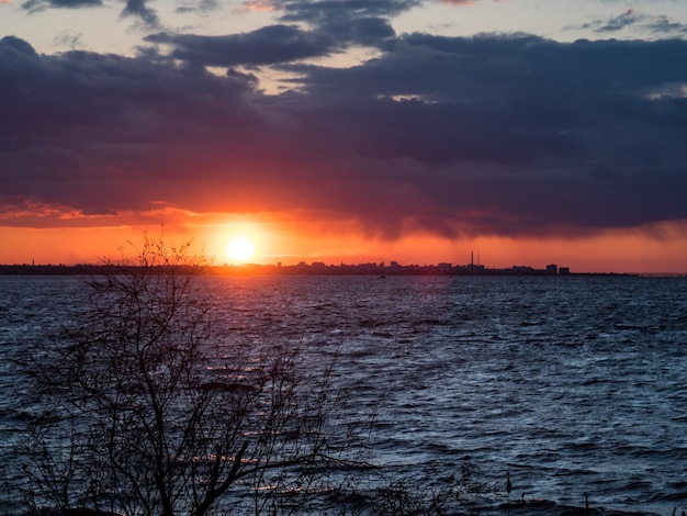 vurige rode zonsondergang boven de stad Zonsondergang tussen wolk en stad