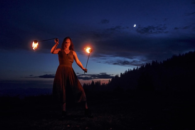 Vuurshow door vrouw in jurk in nacht Karfatische bergen Prachtig landschap