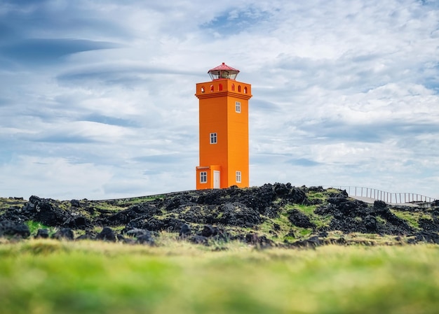 Vuurtoren aan de kust in het IJslandse IJslandse landschap in de zomer Beroemde plaats IJsland reisbeeld