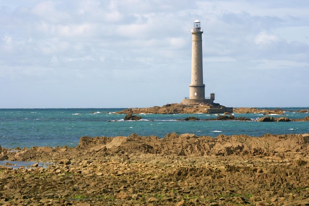 Vuurtoren aan zee tegen een bewolkte hemel