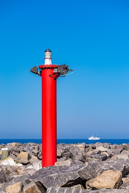 Foto vuurtoren bij de zee tegen een heldere blauwe hemel