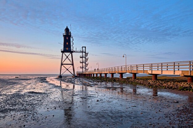 Foto vuurtoren bij zee tegen de hemel bij zonsondergang