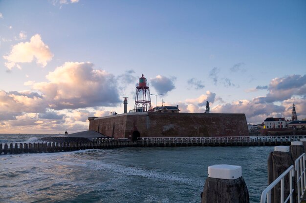 Vuurtoren door de zee tegen de lucht