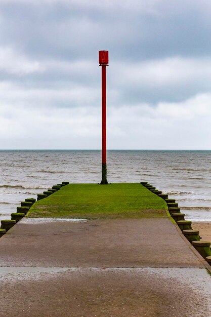 Vuurtoren door de zee tegen de lucht