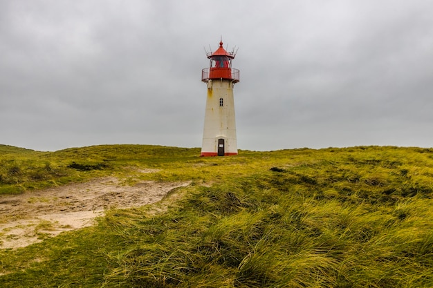 Vuurtoren door de zee tegen de lucht