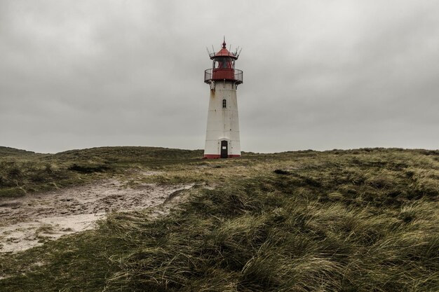 Vuurtoren door de zee tegen de lucht
