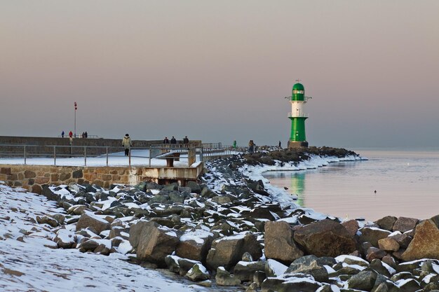 Foto vuurtoren op de pier op zee tegen de hemel in de winter