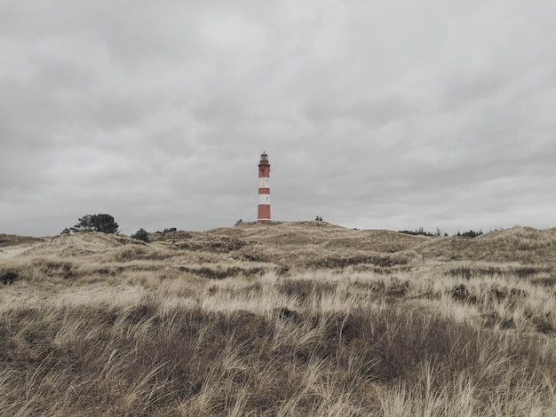 Vuurtoren op een grasveld tegen de lucht