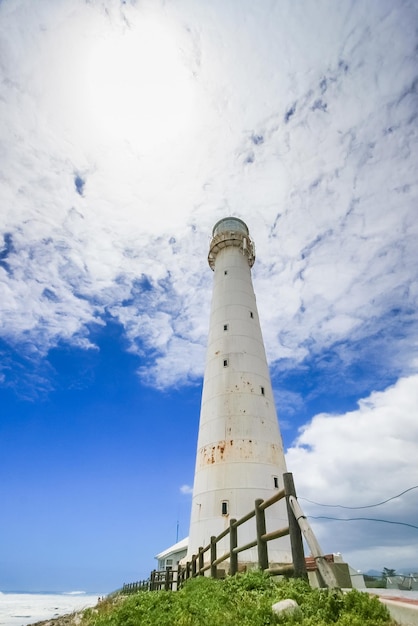 Vuurtoren op een ruige kustlijn overdag. Gefotografeerd in Kaapstad, Zuid-Afrika aan de westkust van het schiereiland