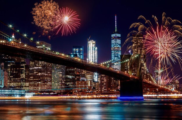 Vuurwerk boven de rivier en verlichte gebouwen's nachts