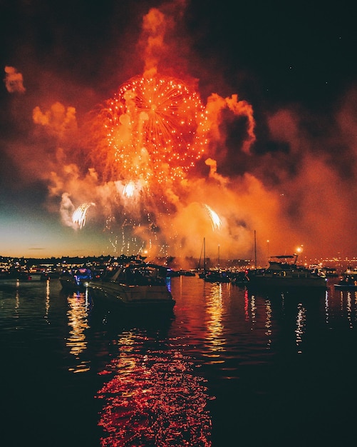 Foto vuurwerk boven de zee tegen de hemel's nachts