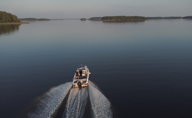 Vyborg Russia August 17 2022 A boat rushing along the water surface of the picturesque Vyborg Bay Two people in a boat Boat trip