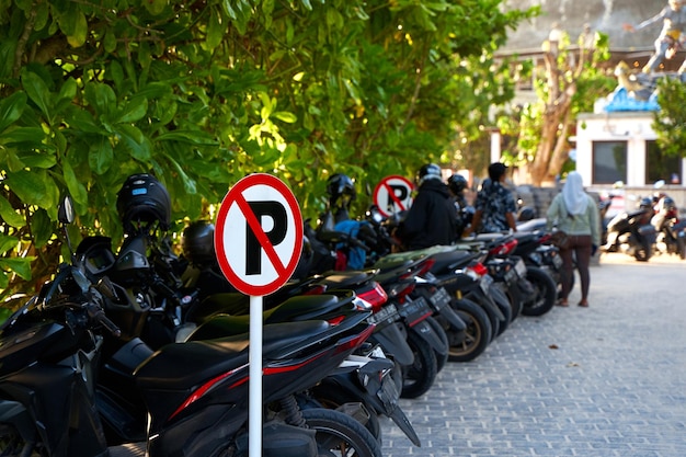 Foto waarschuwingsbord parkeer is verboden volledige motorfietsparkeerplaats in de buurt van een verboden parkeerbord