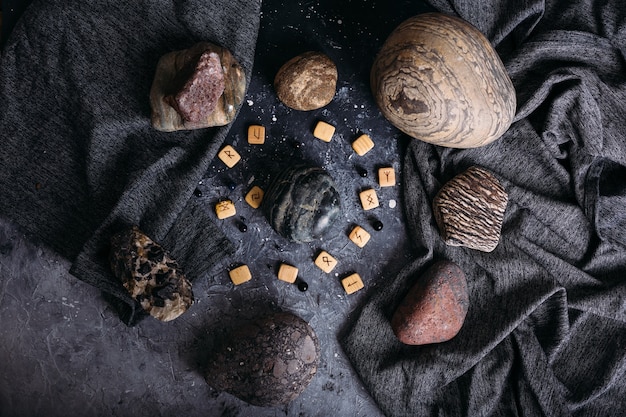 Foto waarzeggerij op houten runen tussen stenen sombere en mysterieuze heksentafel