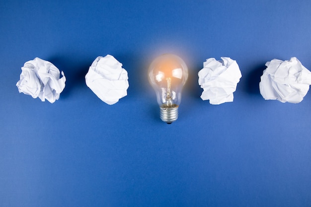 Wad of paper and lamp on blue surface