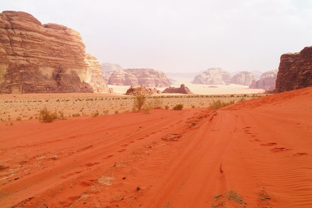 Wadi Rum desert Jordan Middle East known as The Valley of the Moon  Orange sand blue sky haze and clouds Designation as a UNESCO World Heritage Site Red planet Mars landscape