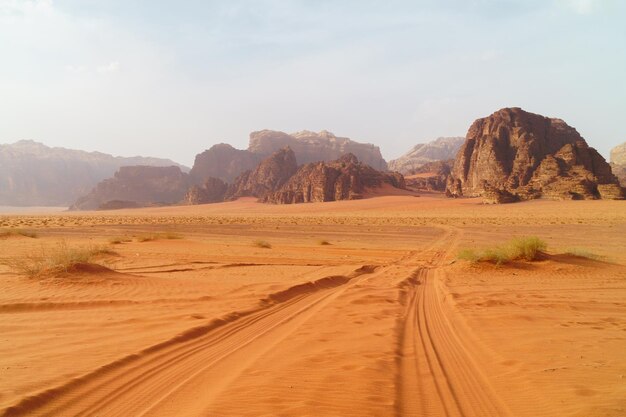 Wadi Rum desert Jordan Middle East known as The Valley of the Moon  Orange sand blue sky haze and clouds Designation as a UNESCO World Heritage Site Red planet Mars landscape