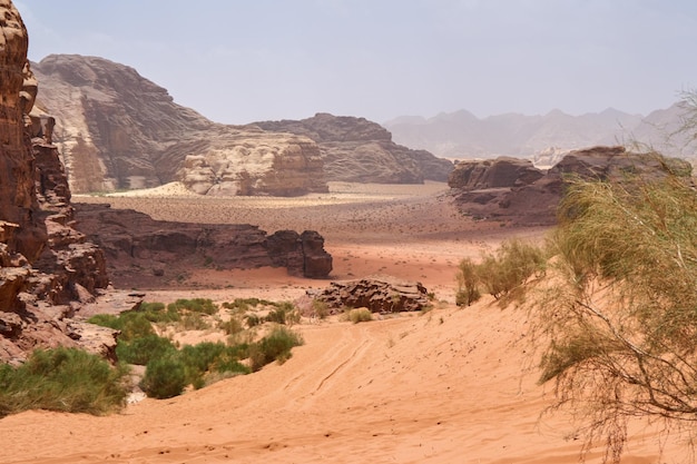 Wadi Rum desert Jordan Middle East The Valley of the Moon Orange sand haze clouds Designation as a UNESCO World Heritage Site National park outdoors landscape Offroad adventures travel background