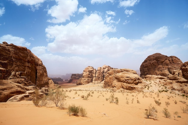 Wadi Rum-woestijn Jordanië Midden-Oosten De Vallei van de Maan Oranje zandnevelwolken Aanwijzing als UNESCO-werelderfgoed Rode planeet Marslandschap Offroad avonturen reizen achtergrond