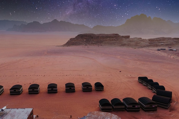 Wadi Rum woestijn Jordanië Zwart textiel camping tenten in de buurt van de rotsen Oranje zand Melkweg hemel