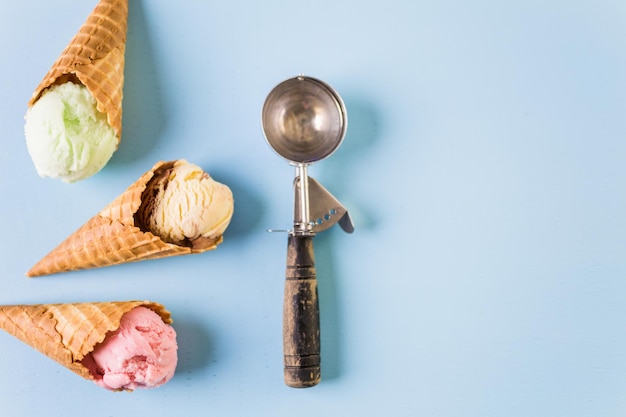 Wafel ijshoorntjes met bolletjes ijs op een blauwe achtergrond.