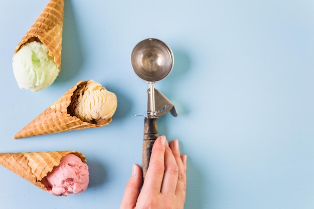 Wafel ijshoorntjes met bolletjes ijs op een blauwe achtergrond.