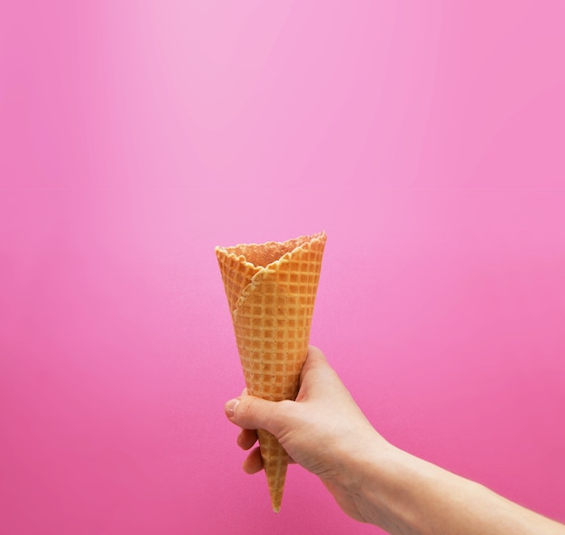 Wafel in de hand op een felroze achtergrond