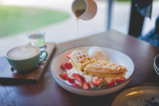 Wafel pannenkoek dessert met vanille-ijs verse aardbeien en honingsiroop